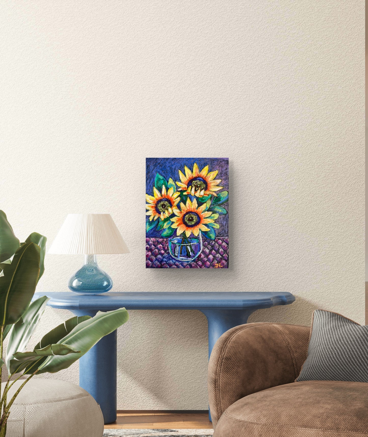Colorful sunflower painting on a wall above a blue table with a lamp and plant.