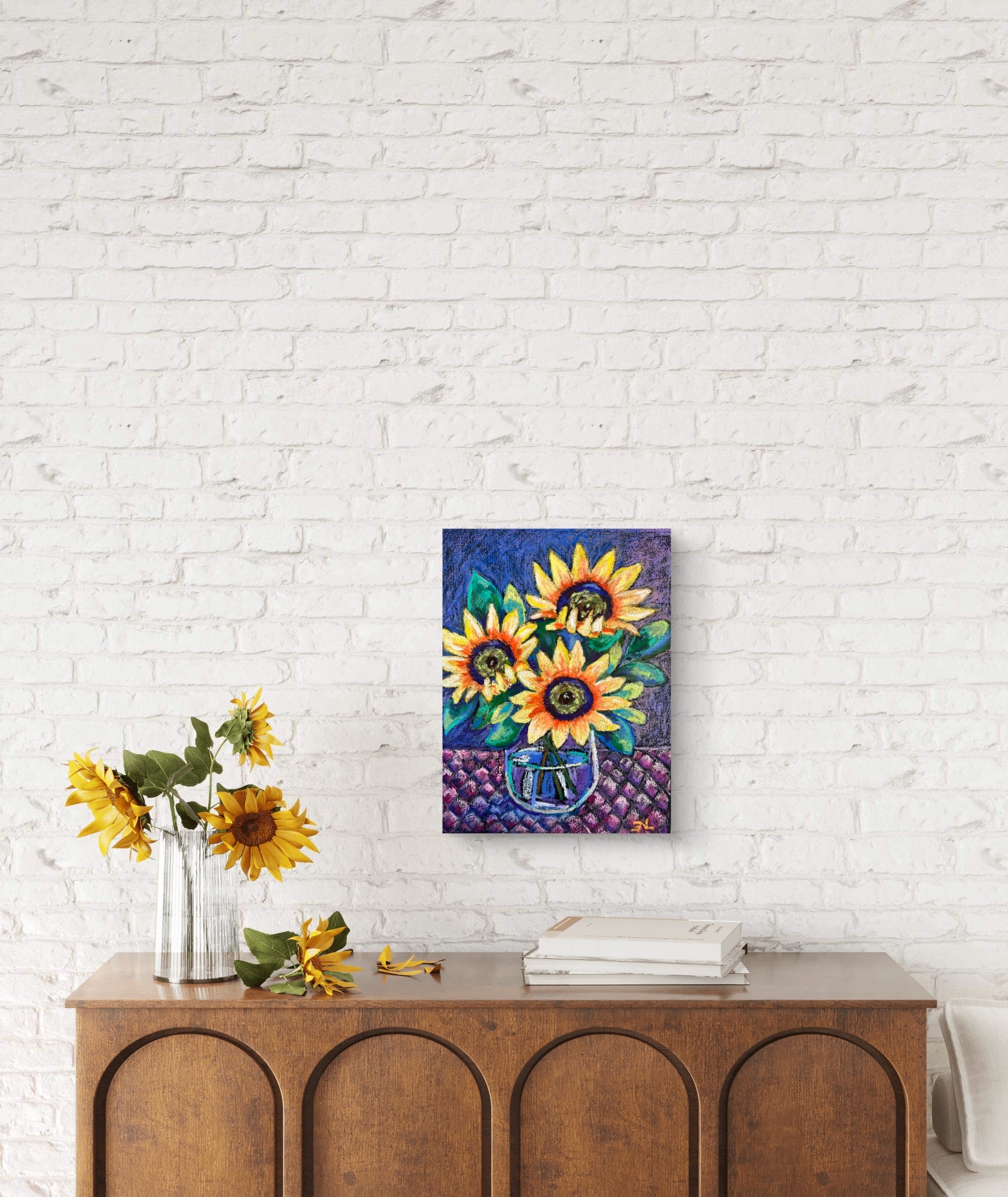 Colorful sunflower painting on a white brick wall above a wooden console table.
