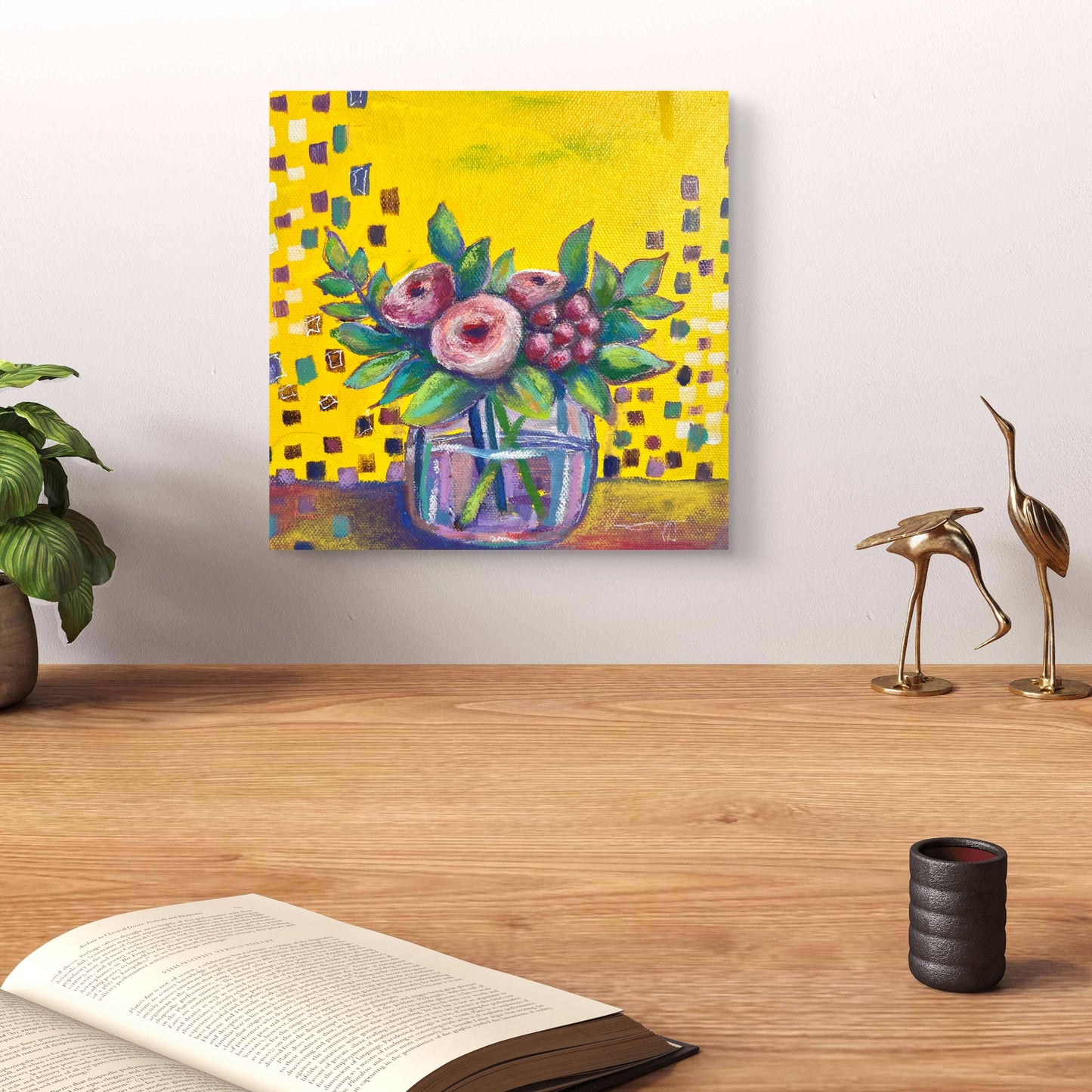 Colorful floral painting on a wall above a wooden surface with decor items.