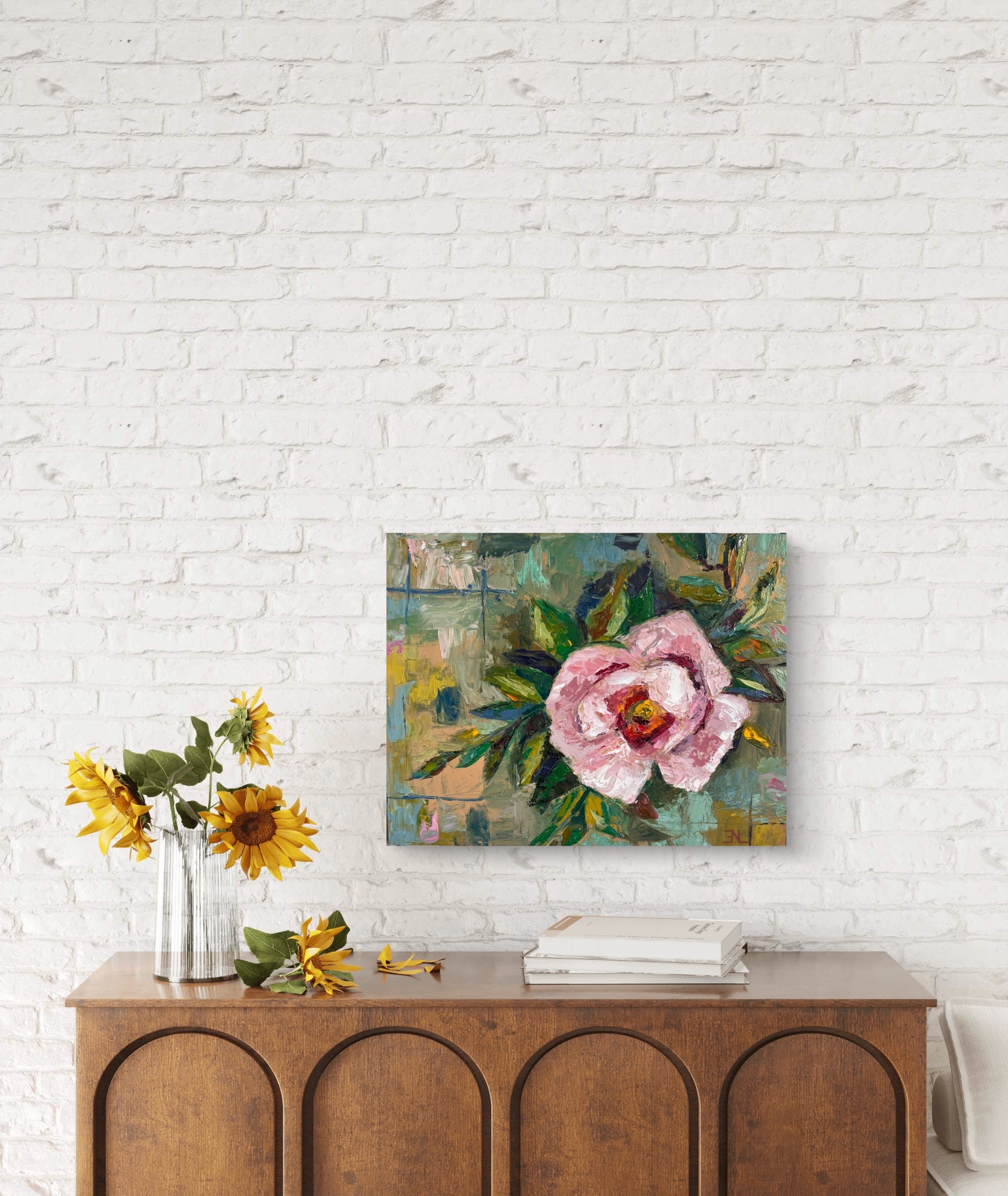 Floral painting on a white brick wall above a wooden console table with sunflowers.