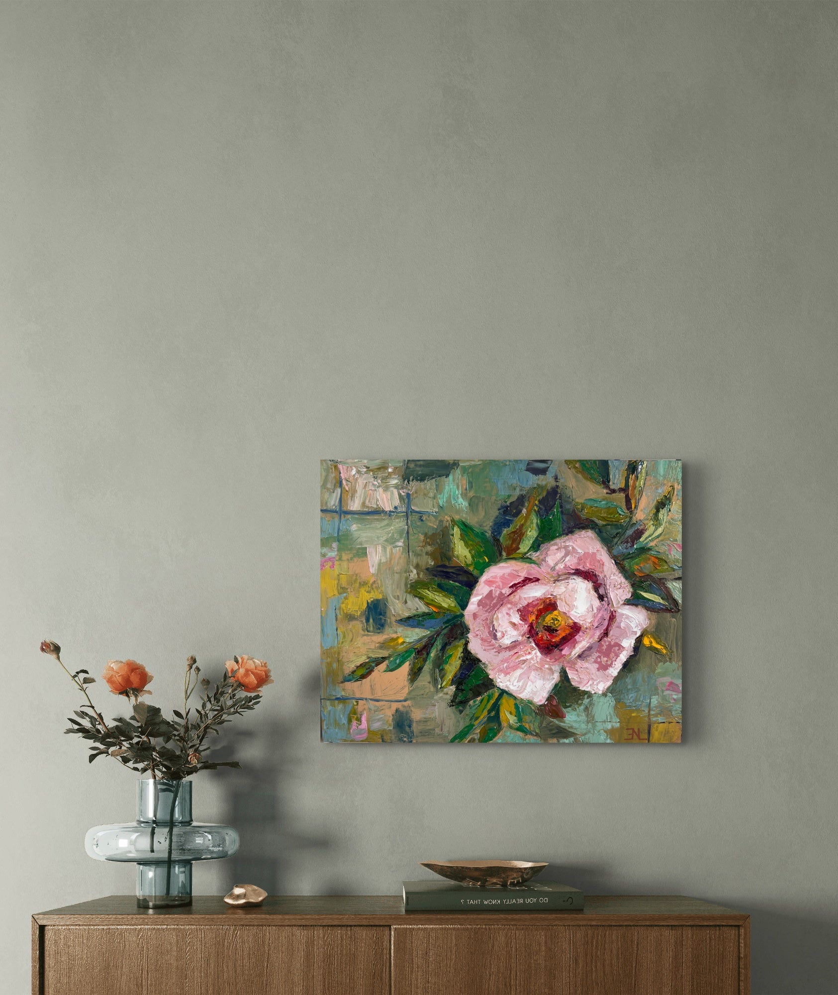 Floral painting on a wall above a wooden cabinet with decorative items.